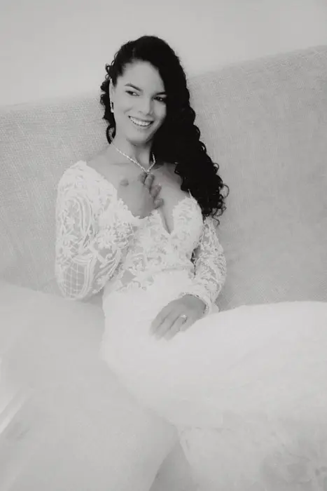 Hochzeitsfotograf Bayern Braut in elegantem weißen Kleid posiert auf einem Sofa Dokumentarische Editorial Hochzeitsfotografie