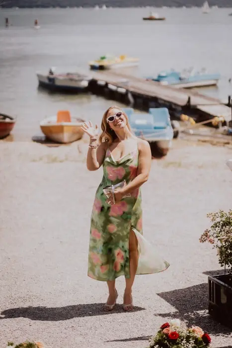 Hochzeitsfotograf Bayern Frau in Sommerkleid am See mit Booten im Hintergrund Dokumentarische Editorial Hochzeitsfotografie