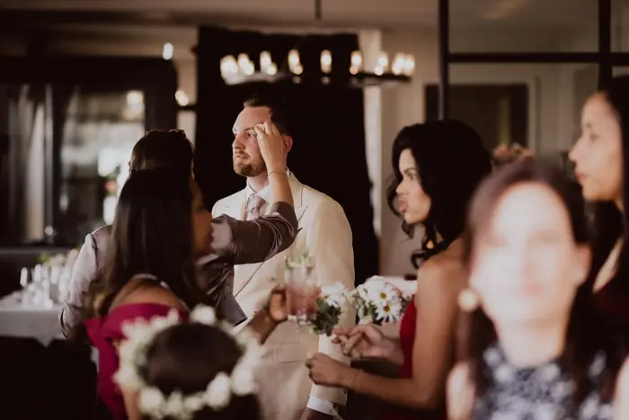 Hochzeitsfotograf Bayern Brautparty bereitet Bräutigam im eleganten Raum vor Dokumentarische Editorial Hochzeitsfotografie