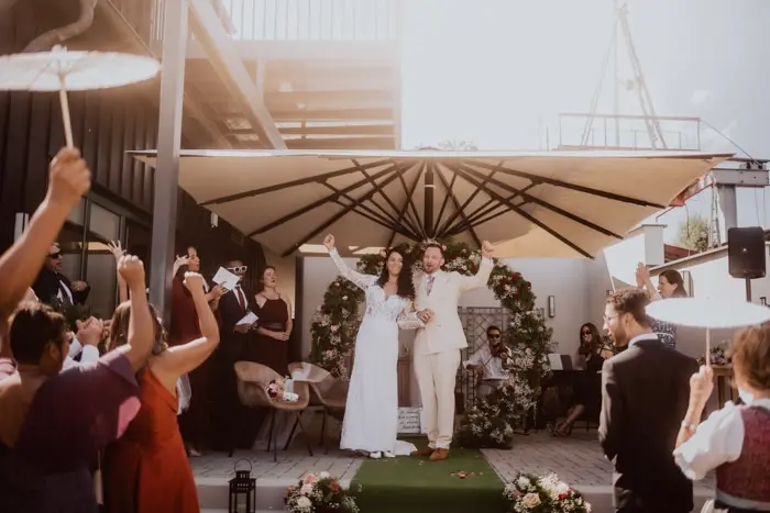 Hochzeitsfotograf Bayern Moderne Hochzeit im Freien mit Brautpaar und Gästen unter Sonnenschirm Dokumentarische Editorial Hochzeitsfotografie