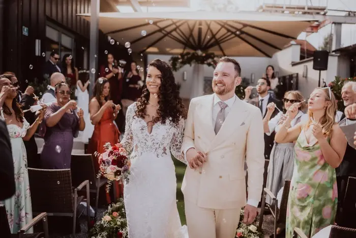 Hochzeitsfotograf Bayern Brautpaar nach Hochzeit, lächelnd, umgeben von Gästen, künstlerische Atmosphäre Dokumentarische Editorial Hochzeitsfotografie