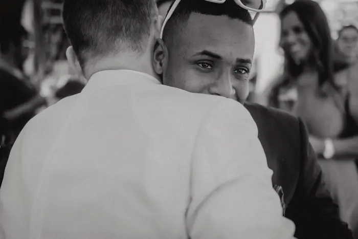 Hochzeitsfotograf Bayern Zwei Männer umarmen sich auf einer Veranstaltung Dokumentarische Editorial Hochzeitsfotografie