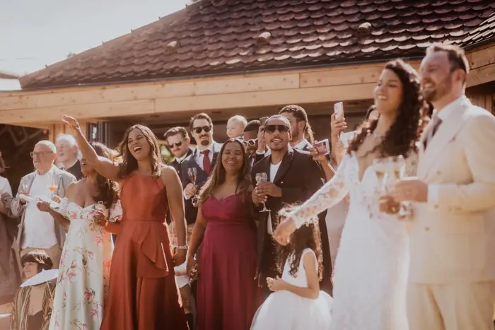 Hochzeitsfotograf Bayern Hochzeitspaar mit Gästen bei Empfang unter freiem Himmel Dokumentarische Editorial Hochzeitsfotografie