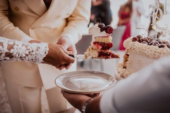 Hochzeitsfotograf Bayern Hochzeitstorte wird beim Empfang serviert Dokumentarische Editorial Hochzeitsfotografie