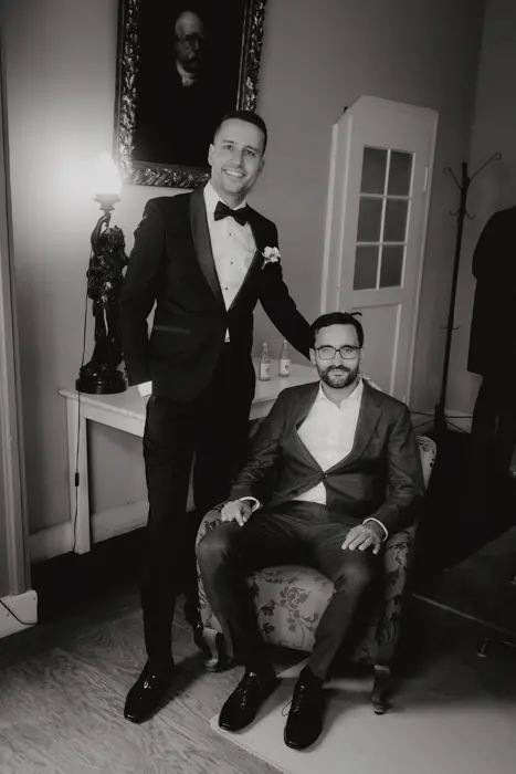 Hochzeitsfotograf Bayern Zwei Männer in Anzügen posieren elegant in einem stilvollen Raum Dokumentarische Editorial Hochzeitsfotografie