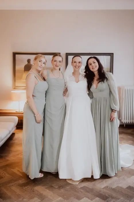 Hochzeitsfotograf Bayern Vier Frauen in formeller Kleidung in einem elegant eingerichteten Zimmer Dokumentarische Editorial Hochzeitsfotografie