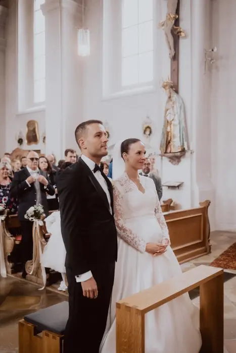 Hochzeitsfotograf Bayern Brautpaar bei kirchlicher Hochzeit in einer dekorierten Kirche Dokumentarische Editorial Hochzeitsfotografie