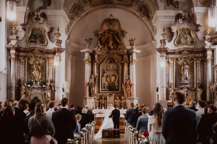 Hochzeitsfotograf Bayern Brautpaar in historischer Kirche bei Hochzeitszeremonie Dokumentarische Editorial Hochzeitsfotografie