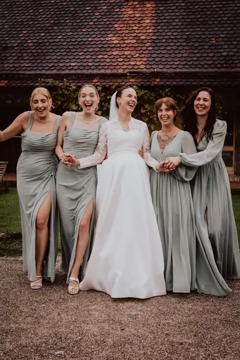 Hochzeitsfotograf Bayern Glückliche Braut mit vier Brautjungfern in eleganten Kleidern Dokumentarische Editorial Hochzeitsfotografie