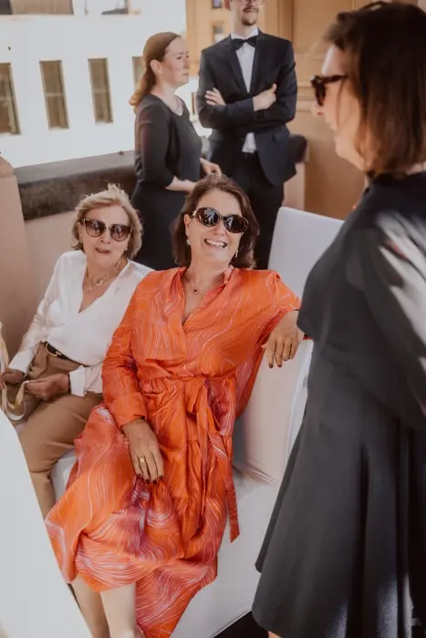 Hochzeitsfotograf Bayern Frauen in stilvoller Kleidung bei einem gesellschaftlichen Event im Freien Dokumentarische Editorial Hochzeitsfotografie