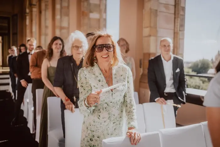 Hochzeitsfotograf Bayern Ältere Frau in Sonnenbrille bei einer feierlichen Veranstaltung im Freien Dokumentarische Editorial Hochzeitsfotografie