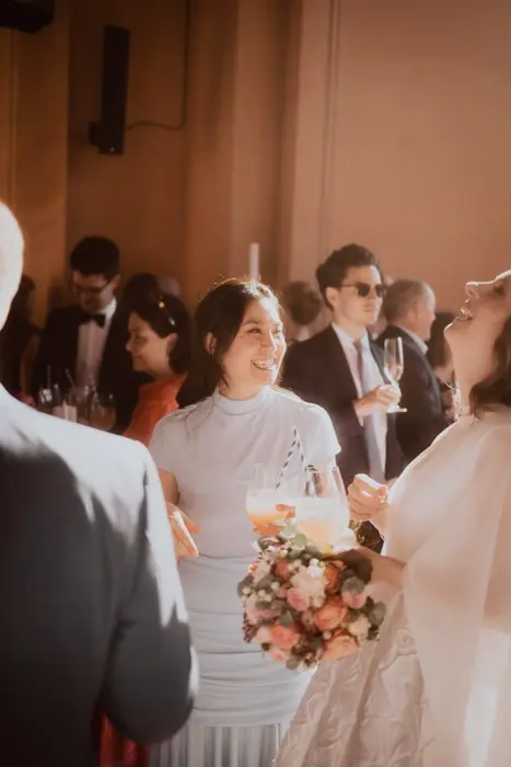 Hochzeitsfotograf Bayern Fröhliche Teilnehmer auf einer eleganten Party mit Getränken Dokumentarische Editorial Hochzeitsfotografie