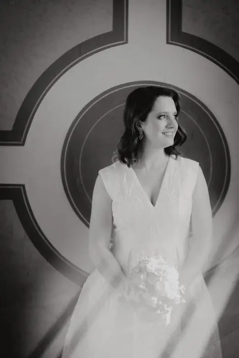 Hochzeitsfotograf Bayern Braut in elegantem Kleid vor geometrischem Hintergrund Dokumentarische Editorial Hochzeitsfotografie