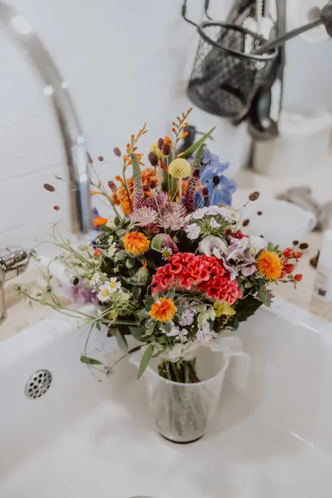 Hochzeitsfotograf Bayern Bunter Wildblumenstrauß in einem Küchenbecken Dokumentarische Editorial Hochzeitsfotografie