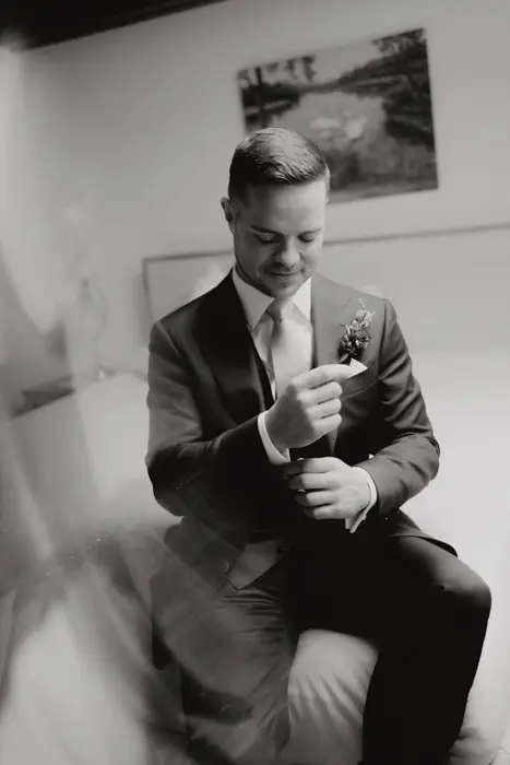 Hochzeitsfotograf Bayern Schwarz-Weiß-Porträt eines Bräutigams im Anzug, der sich vorbereitet Dokumentarische Editorial Hochzeitsfotografie