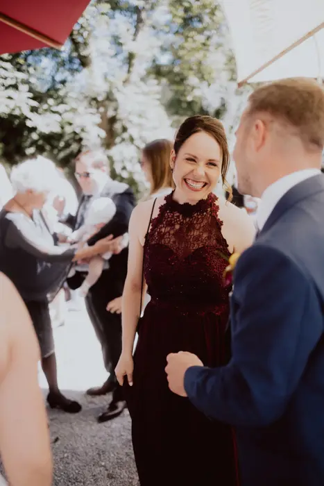 Hochzeitsfotograf Bayern Frau in elegantem Abendkleid bei einer Outdoor-Veranstaltung Dokumentarische Editorial Hochzeitsfotografie