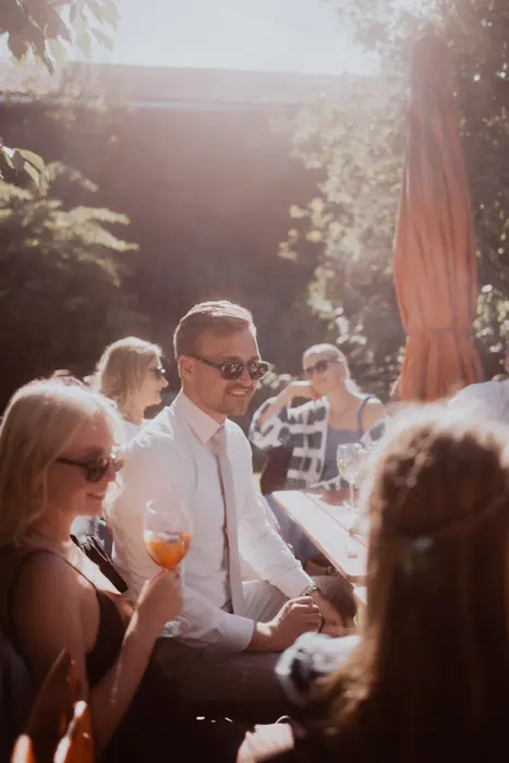 Hochzeitsfotograf Bayern Gruppe von Freunden genießt sonnigen Tag im Freien Dokumentarische Editorial Hochzeitsfotografie