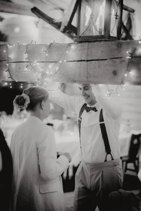 Hochzeitsfotograf Bayern Paar tanzt glücklich bei einer Hochzeitsfeier unter Lichterketten Dokumentarische Editorial Hochzeitsfotografie