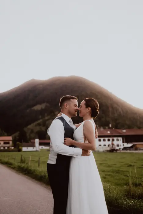 Hochzeitsfotograf Bayern Hochzeitspaar vor Berglandschaft bei Sonnenuntergang Dokumentarische Editorial Hochzeitsfotografie