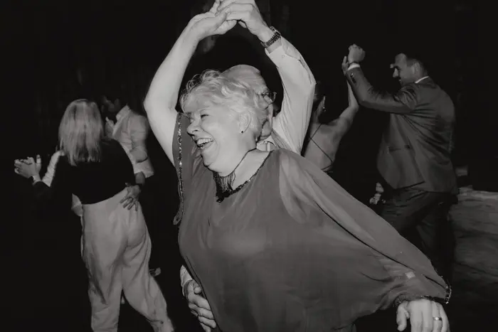 Hochzeitsfotograf Bayern Ältere Frau tanzt glücklich auf einer Party Dokumentarische Editorial Hochzeitsfotografie