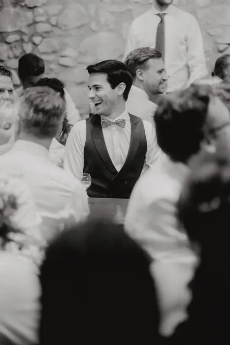 Hochzeitsfotograf Bayern Mann im Anzug lächelt bei einer Hochzeit Dokumentarische Editorial Hochzeitsfotografie