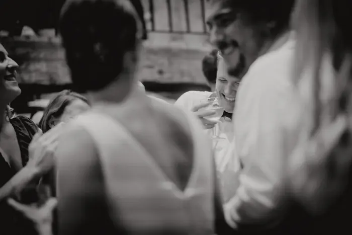 Hochzeitsfotograf Bayern Schwarz-Weiß-Foto von Menschen bei einer Feier oder Hochzeit Dokumentarische Editorial Hochzeitsfotografie