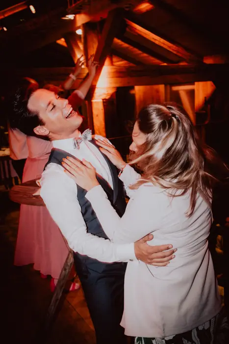 Hochzeitsfotograf Bayern Paar tanzt glücklich auf einer Hochzeit in gedämpftem Licht Dokumentarische Editorial Hochzeitsfotografie