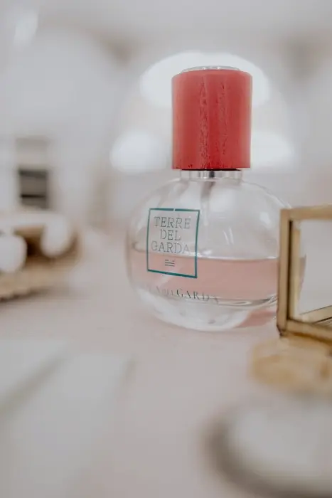 Hochzeitsfotograf Bayern Parfümflasche mit rotem Deckel auf hellem Hintergrund Dokumentarische Editorial Hochzeitsfotografie