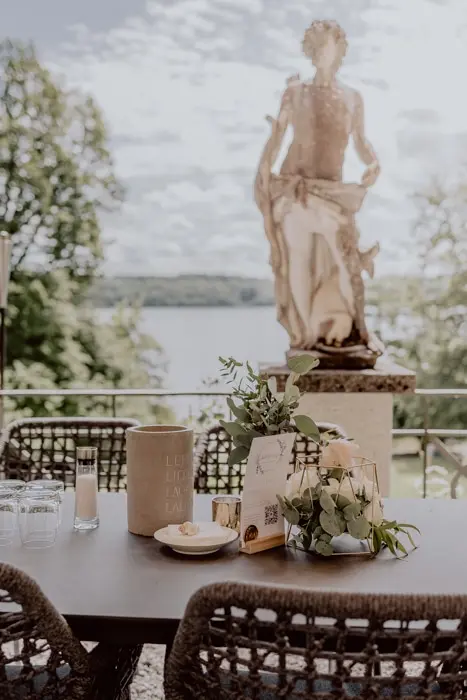 Hochzeitsfotograf Bayern Gartenrestaurant mit Seeblick und griechischer Statue im Freien Dokumentarische Editorial Hochzeitsfotografie