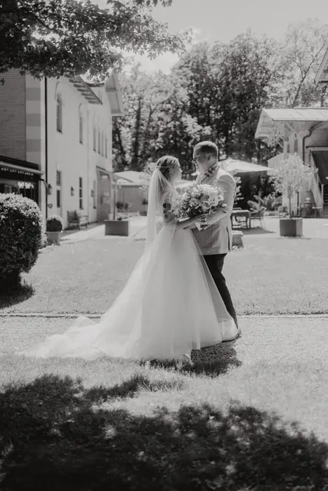 Hochzeitsfotograf Bayern Schwarzweißfoto eines Hochzeitspaares in einem Garten Dokumentarische Editorial Hochzeitsfotografie