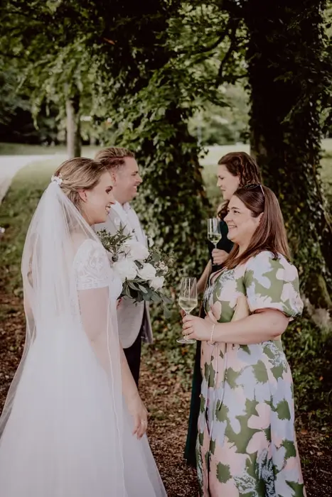 Hochzeitsfotograf Bayern Brautpaar im Gespräch mit Gästen im Wald Dokumentarische Editorial Hochzeitsfotografie