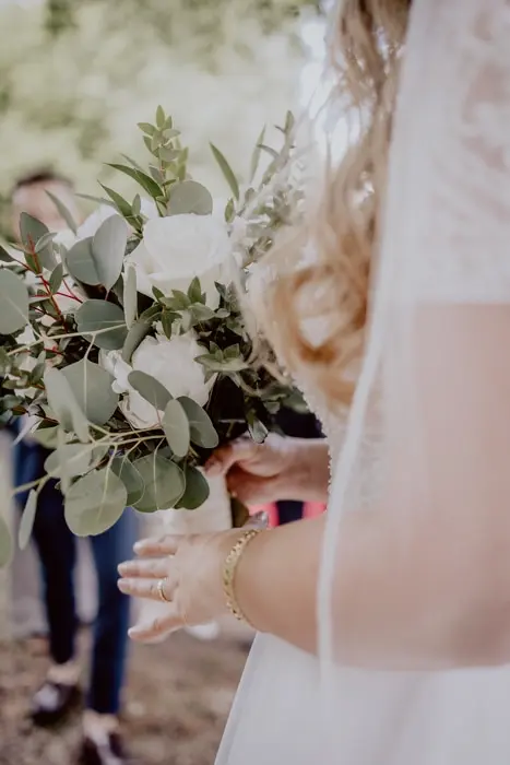 Hochzeitsfotograf Bayern Braut mit Blumenstrauß bei einer Hochzeit im Freien Dokumentarische Editorial Hochzeitsfotografie
