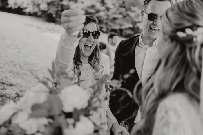 Hochzeitsfotograf Bayern Schwarzweißfoto von Menschen bei einer Hochzeit im Freien Dokumentarische Editorial Hochzeitsfotografie