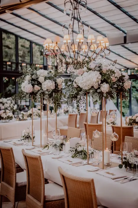 Hochzeitsfotograf Bayern Elegante Hochzeitsdekoration mit Blumen und Kerzenleuchtern in einem modernen Veranstaltungsort Dokumentarische Editorial Hochzeitsfotografie