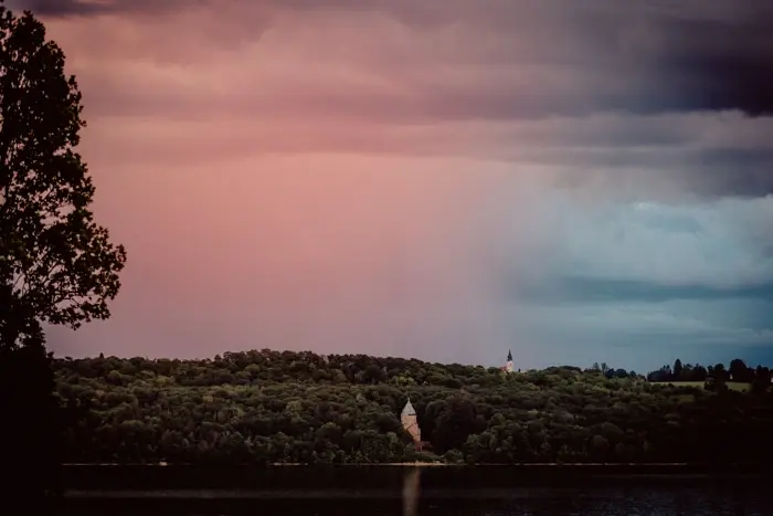 Hochzeitsfotograf Bayern Landschaft mit bewölktem Himmel und Wald im Sonnenuntergang Dokumentarische Editorial Hochzeitsfotografie