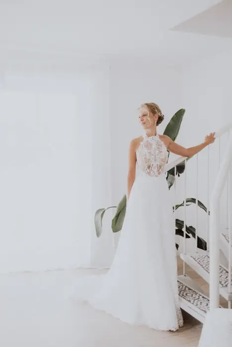 Hochzeitsfotograf Bayern Braut in elegantem weißen Kleid auf moderner Treppe Dokumentarische Editorial Hochzeitsfotografie