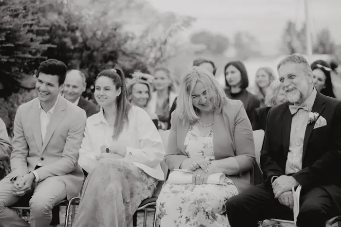 Hochzeitsfotograf Bayern Schwarz-weiß Foto von Gästen bei einer Hochzeit im Freien Dokumentarische Editorial Hochzeitsfotografie