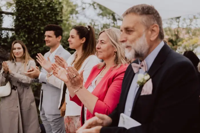 Hochzeitsfotograf Bayern Gruppe von Menschen klatscht bei einer Outdoor-Veranstaltung Dokumentarische Editorial Hochzeitsfotografie