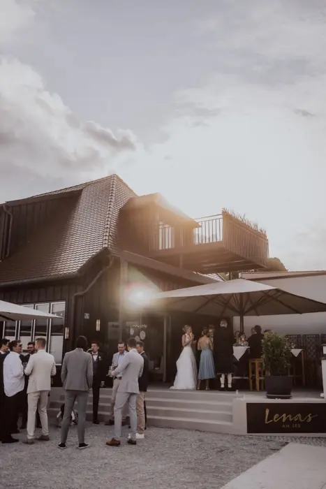 Hochzeitsfotograf Bayern Hochzeitsfeier im Freien bei einem Landhaus bei Sonnenuntergang Dokumentarische Editorial Hochzeitsfotografie