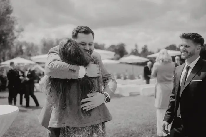 Hochzeitsfotograf Bayern Glückliches Paar umarmt sich bei der Hochzeit im Freien Dokumentarische Editorial Hochzeitsfotografie