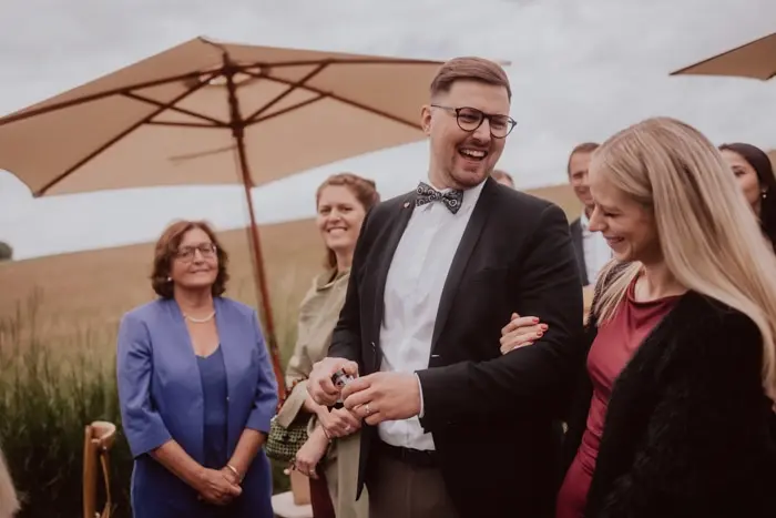 Hochzeitsfotograf Bayern Fröhliche Hochzeitsgäste unter Sonnenschirmen Dokumentarische Editorial Hochzeitsfotografie