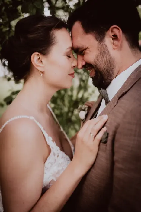 Hochzeitsfotograf Bayern Ein Hochzeitspaar in liebevoller Umarmung bei einer Outdoor-Zeremonie Dokumentarische Editorial Hochzeitsfotografie