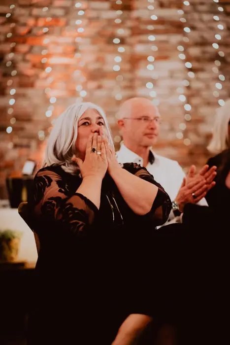 Hochzeitsfotograf Bayern Frau mit grauem Haar überrascht in festlicher Veranstaltung Dokumentarische Editorial Hochzeitsfotografie