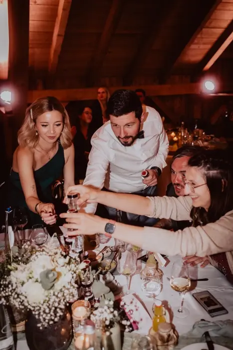 Hochzeitsfotograf Bayern Gruppe von Freunden stößt bei einer Party an Dokumentarische Editorial Hochzeitsfotografie