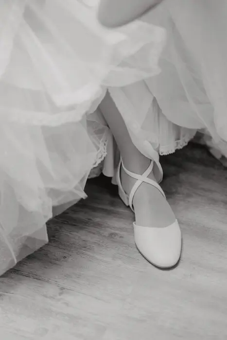 Hochzeitsfotograf Bayern Ballerina in weißen Schuhen auf Holzfußboden Dokumentarische Editorial Hochzeitsfotografie
