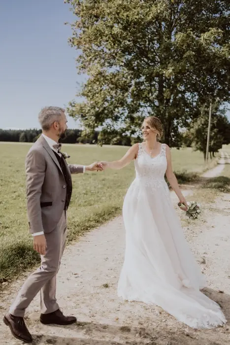 Hochzeitsfotograf Bayern Brautpaar im Freien auf einem Landweg Dokumentarische Editorial Hochzeitsfotografie