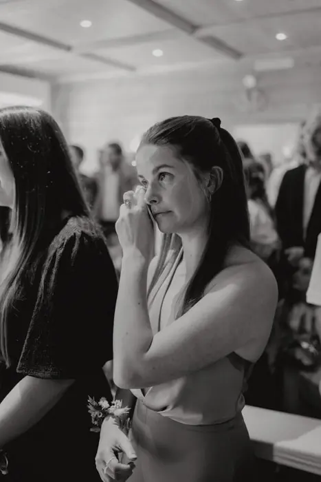 Hochzeitsfotograf Bayern Frau wischt Träne bei einer Veranstaltung weg Dokumentarische Editorial Hochzeitsfotografie