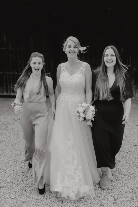 Hochzeitsfotograf Bayern Schwarzweißfoto, Braut mit zwei Frauen im Freien Dokumentarische Editorial Hochzeitsfotografie