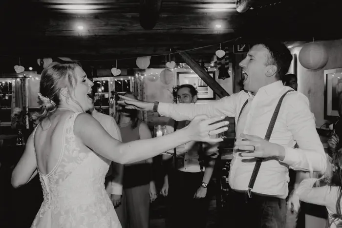 Hochzeitsfotograf Bayern Brautpaar tanzt und feiert auf Hochzeitsfeier in Schwarz-Weiß-Foto Dokumentarische Editorial Hochzeitsfotografie