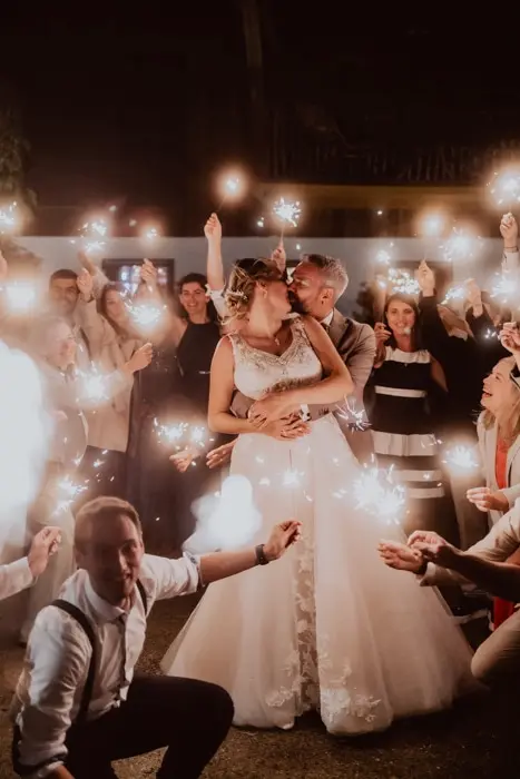 Hochzeitsfotograf Bayern Hochzeitspaar tanzt nachts mit Wunderkerzen umgeben von Gästen Dokumentarische Editorial Hochzeitsfotografie